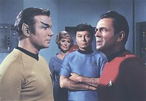 Scotty pohlížející na Kirka, sice živého, ale změněnéhona Romulana
