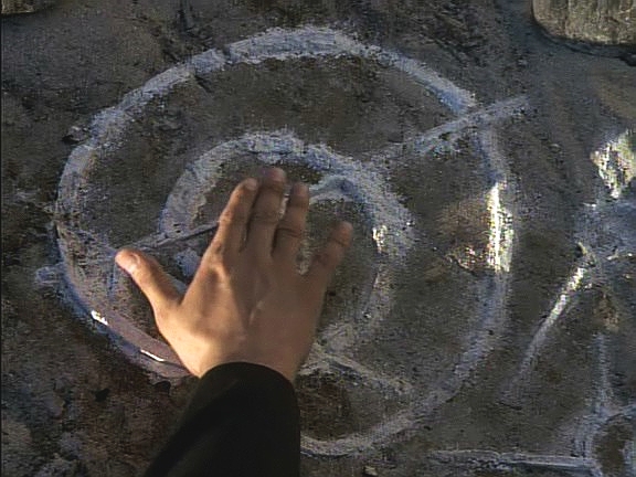 Na nejmenovaném měsíci objeví výsadek z Voyageru známky něčí přítomnosti. Chakotay ten symbol zná a dokonce si vzpomíná, co znamená.