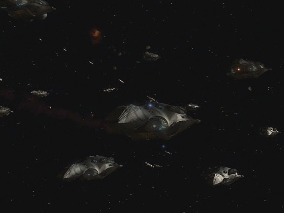 Voyageru to umožnilo nabrat výšku potřebnou ke skoku do warpu. Nad planetou bojují Vaadwaurové s Tureii. Řada vaadwaurských lodí uniká do subprostorových koridorů.
