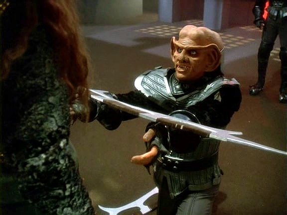 Quark - tedy Worf - Thopoka nakonec porazí. Podle klingonské tradice ho nezabije, nýbrž nabídne jeho bat'leth lady Grilce. 