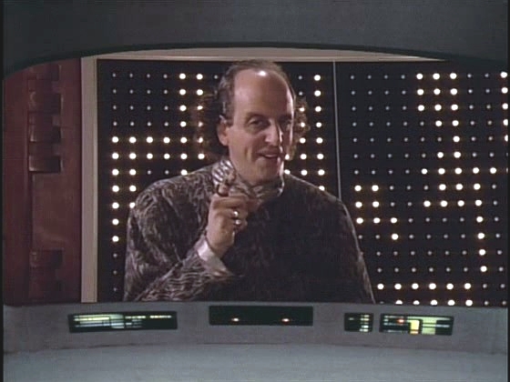 Enterprise pátrající nad planetou Minos po zmizelé lodi Drake kontaktuje nahraná reklamní sekvence dealera se zbraněmi.