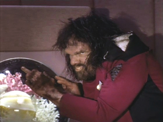 Riker se změnil v australopitheca a snaží se sežrat kapitánovu rybičku.