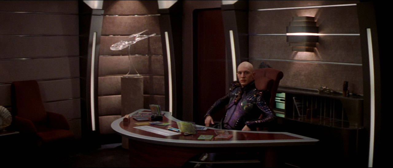 Uprostřed bitvy se Shinzon (jeho holoprojekce) schází s Picardem v jeho pracovně a vyzývá ho, aby se vzdal.