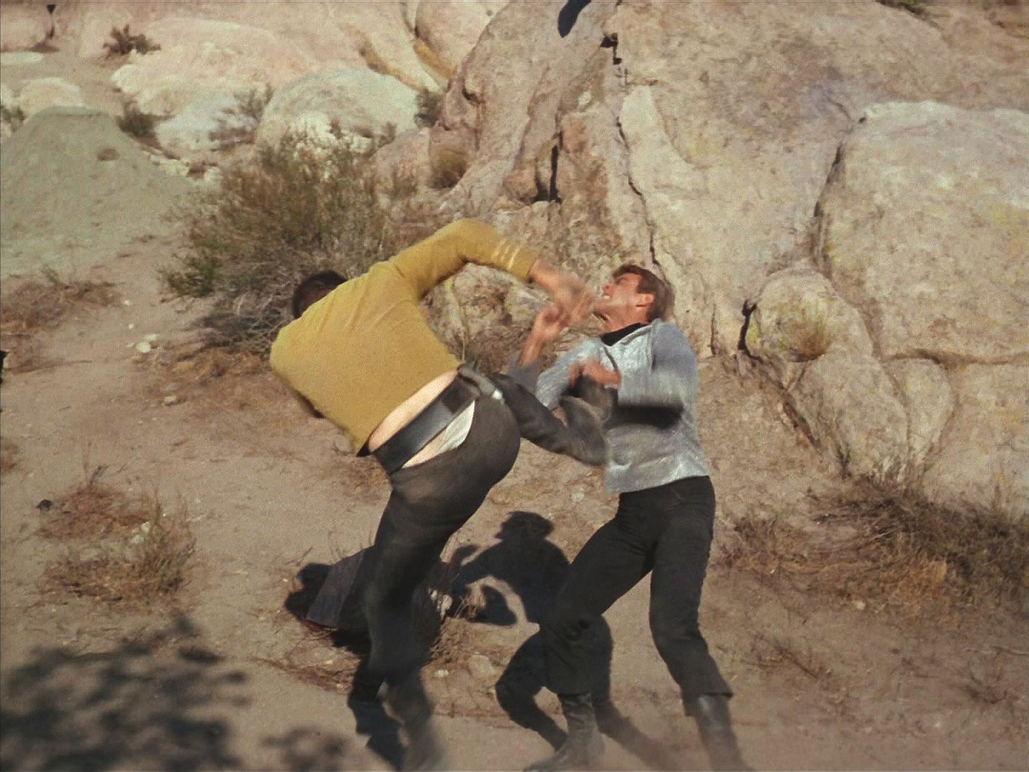 Kirk se ve rvačce trváním hodné Gregoryho Pecka a Charltona Hestona ve Velké zemi snaži dostat z Finnegana, co se to na planetě děje, ale nemá úspěch.