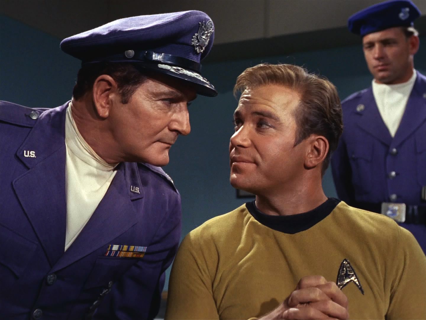 Kirk a Sulu zatím pokračovali do temné komory pro fotky, to však spustilo alarm. Kirk duchapřítomně umožnil Suluovi transportovat se a sám je vyslýchán plukovníkem Fellinim.