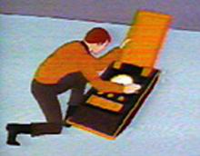Miniaturizovaný Kirk zápasící s komunikátorem