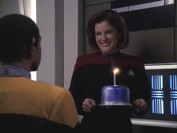 Kapitán konečně vypátrala datum Tuvokových narozenin a přeje mu všechno nejlepší. Ačkoliv není vulkanským zvykem sfouknout svíčku, Tuvok to udělá, aby zamezil riziku požáru.