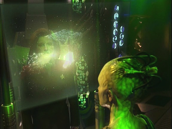 Přenese si hologram kapitána a snaží se ji přesvědčit, aby poskytla antivir. Před jejíma očima ničí jednu loď za druhou a s nimi tisíce životů.