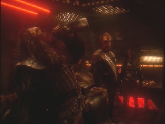 Celá posádka, trochu zahanbená, připíjí krvavým vínem na hrdinskou smrt legendárního mistra Dahar, generála Kora.