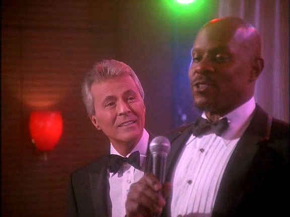 …a to se rázem změní zpátky na Vicův elegantní klub. Kapitán Sisko si s Vicem na oslavu zazpíval.