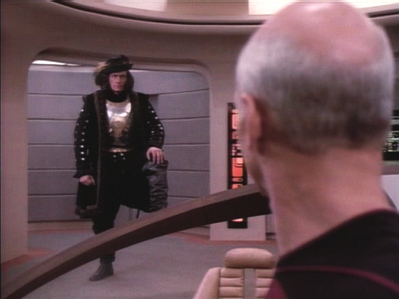 Na můstku se v záblesku světla objeví bytost říkající si Q a nutí kapitána Picarda, aby otočil a vrátil se na Zemi, protože násilnické lidstvo podle něj do vesmíru ještě nepatří.