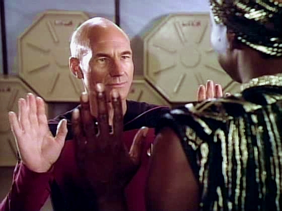 Kapitán Picard se vítá s Lutanem, ligonským vládcem.