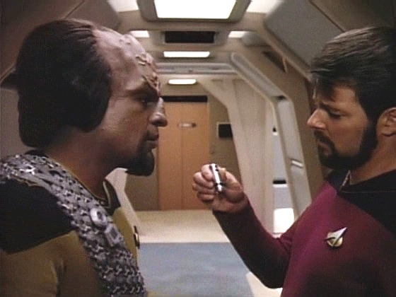 Worf, vědom si, jak velice odlišné jsou klingonské zvyky, dává Rikerovi pro jistotu transpondér se speciální frekvencí.