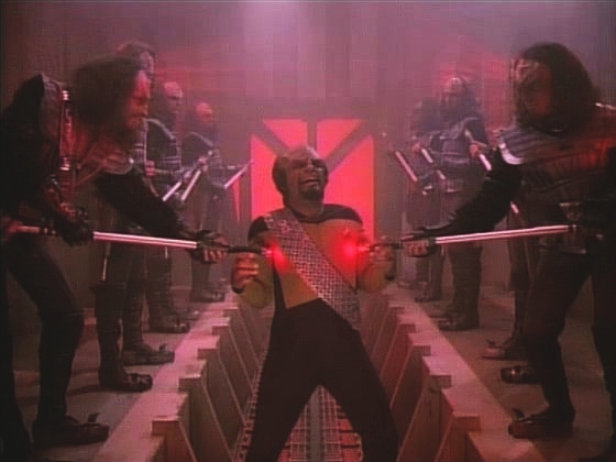 Překvapený a šťastný Worf prochází uličkou lemovanou Klingony s tyčemi bolesti. Místo rodiny ho při tom sledují Wesley, Dat, Geordi, O'Brien a doktorka.
