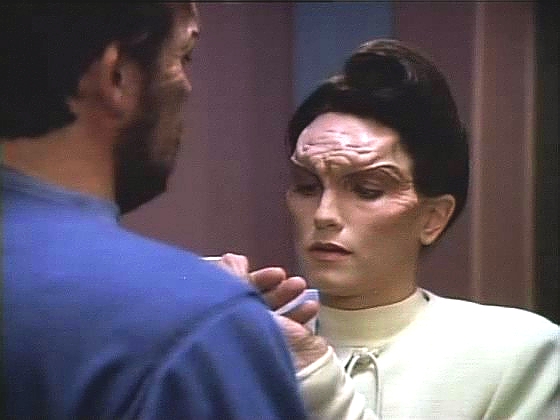 Riker se mezitím v nemocnici uzdravil natolik, že se pokusil utéct. Ošetřovatelka Lanel je ochotná mu pomoci, ovšem požaduje za to intimní styk s mimozemšťanem.