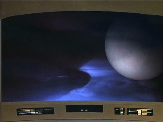 Také planeta v mlhovině se chová podivně: když Enterprise přiletěla na její souřadnice, planeta nikde nebyla, vzápětí se ale objevila.