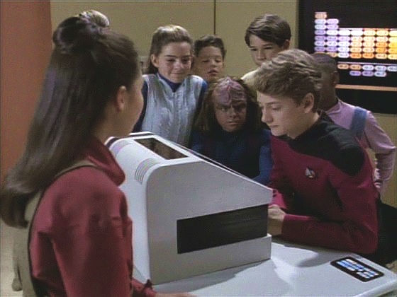Děti teď čekají, až dostanou přístup do počítače. Riker málem k smrti unudí Mortu, když mu vysvětluje, jak fungují systémy lodi, a přitom převede ovládání lodi na školní terminál. 