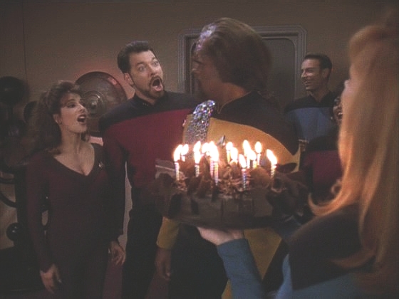 Kolegové nezklamali, party se koná, Worf dostává dárky a čokoládový dort. Kapitán své blahopřání pouze vzkazuje, protože nemůže opustit můstek.
