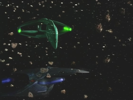 Riker o všem informuje kapitána a navrhuje, aby použili zachráněné maskovací zařízení, které jim umožní průlet hmotou. Romulané sledují, jak se před nimi odmaskovává Enterprise.