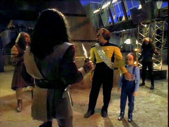 Při návratu jsou přepadeni třemi Klingony. Worfovi pomůže muž, který se představí jako k'mtar Moghova domu. 