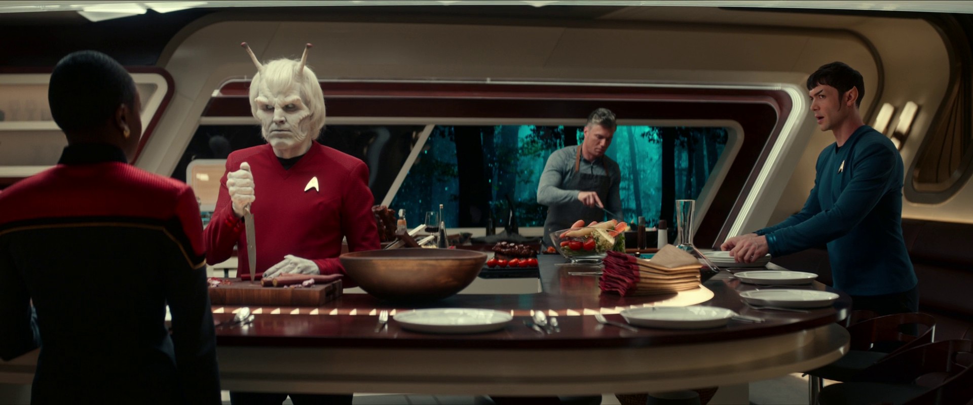 Kapitán Pike pořádá neformální večeři se členy posádky, kam kadet Uhura dle „přátelské“ rady Ericy Ortegas dorazí ve slavnostní uniformě.