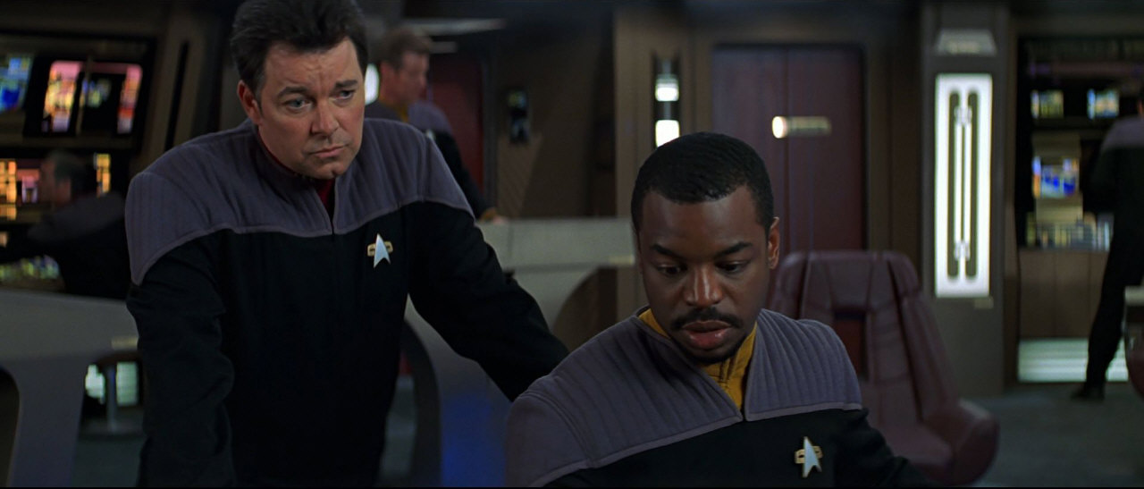 Komandér Riker a Geordi LaForge mají za úkol informovat Radu Federace.